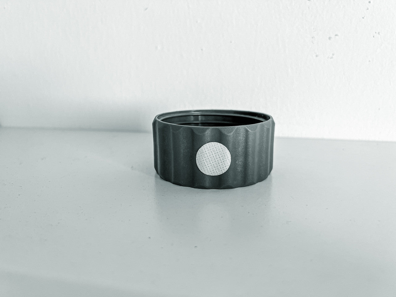 Image of a singular BioCoupler laying flat on a surface.
